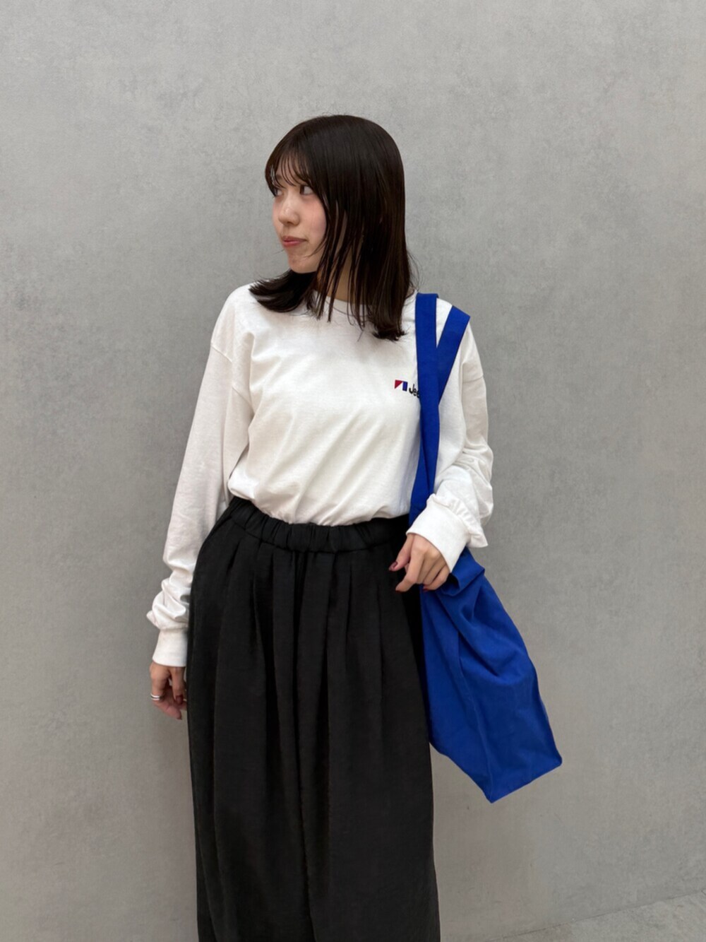グレー系のその他パンツ、ブルー系のトートバッグ、ホワイト系のTシャツ/カットソーを着用したレディースの秋コーディネートの5枚目の写真
