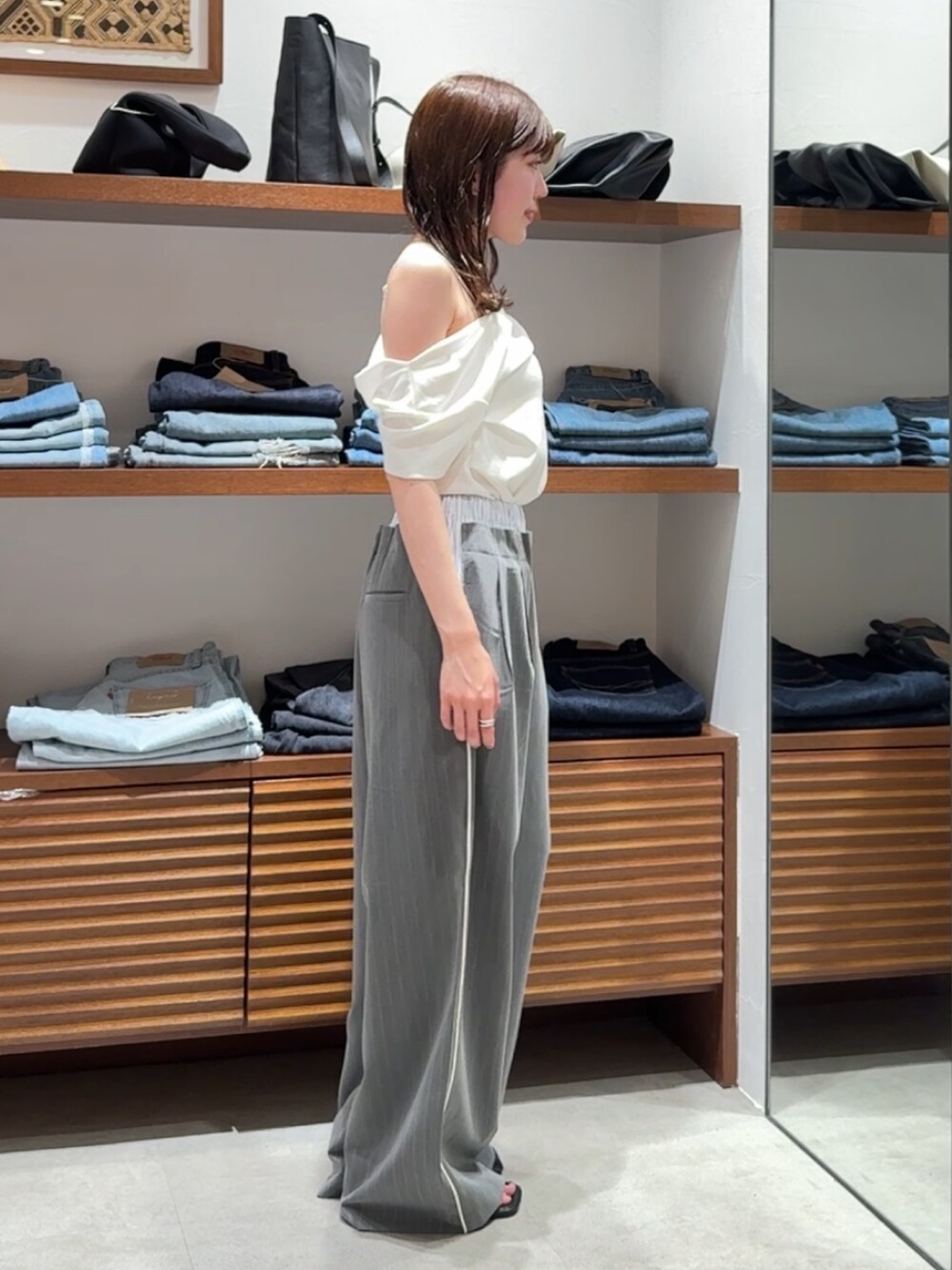グレー系のその他パンツ、ブラック系のサンダル、ホワイト系のTシャツ/カットソーを着用したレディースの春コーディネートの3枚目の写真