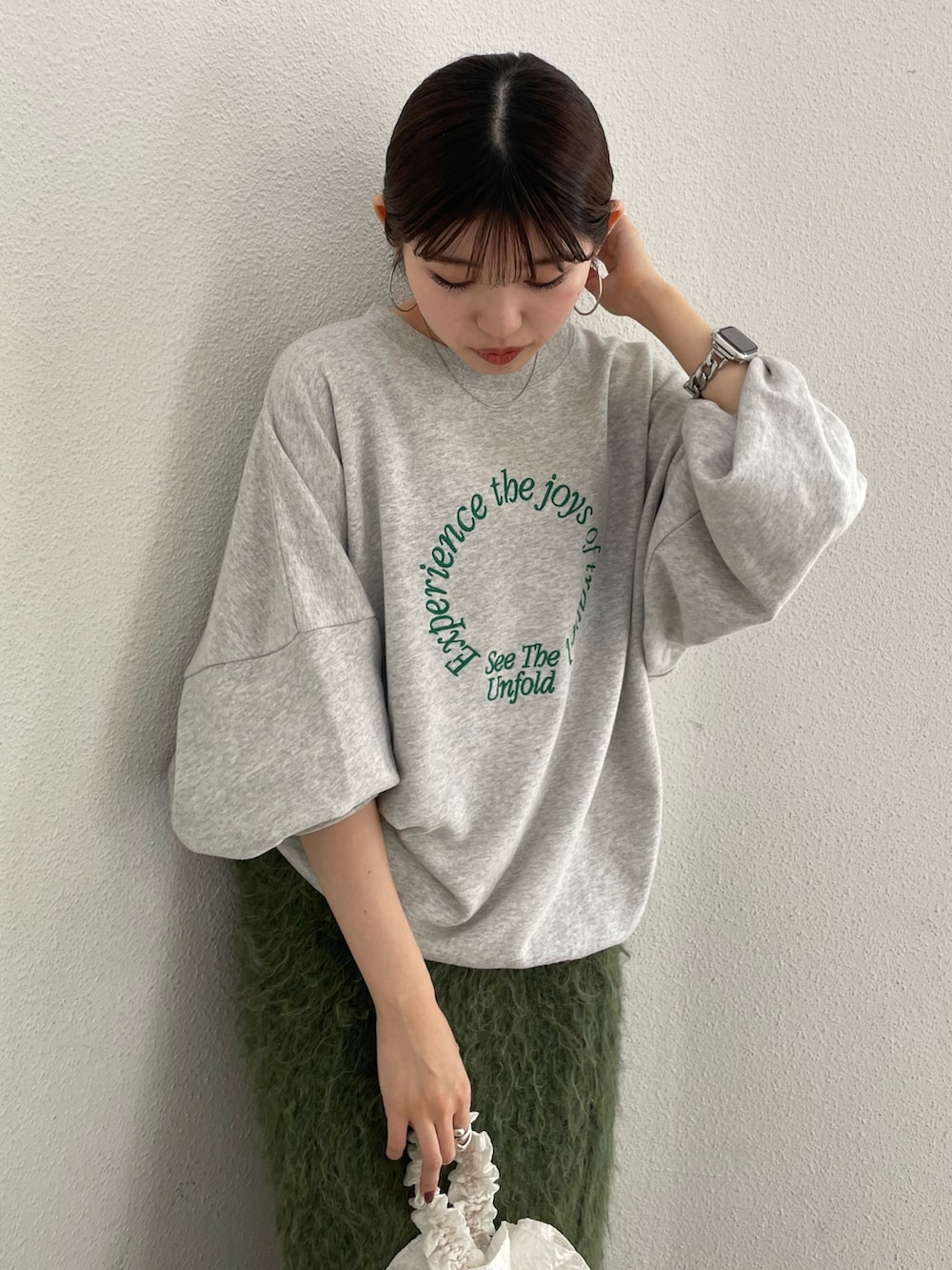 ホワイト系のハンドバッグ、ブラック系のブーツ、グレー系のスウェットを着用したレディースの秋コーディネートの6枚目の写真