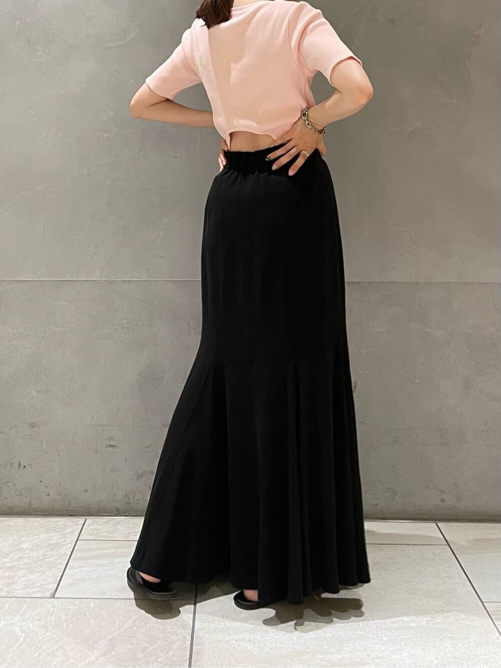 ブラック系のサンダル、ブラック系のスカート、ピンク系のTシャツ/カットソーを着用したレディースの夏コーディネートの4枚目の写真