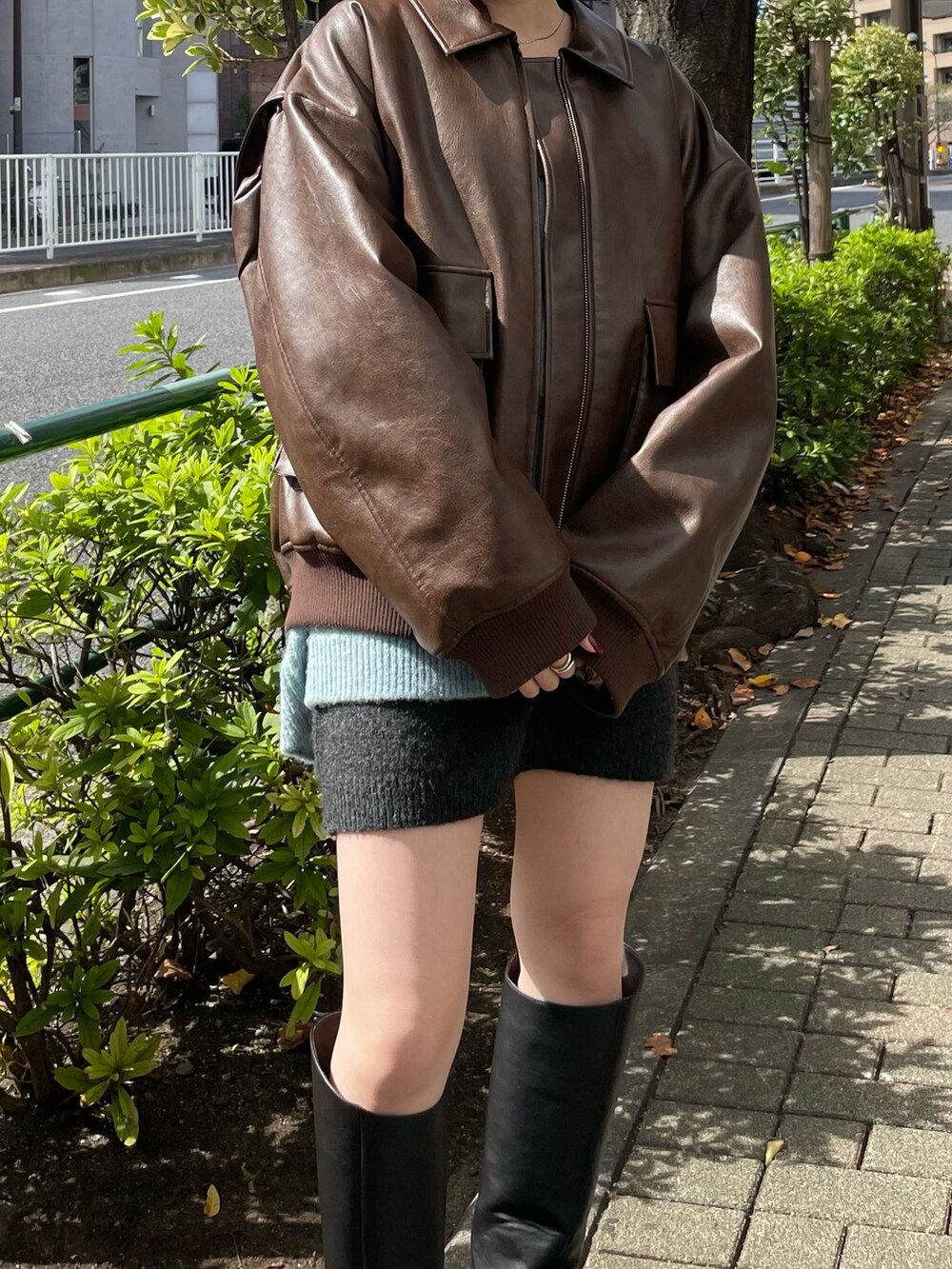 グレー系のスカート、ブラック系のブーツ、ブラウン系のブルゾンを着用したレディースの秋コーディネートの6枚目の写真