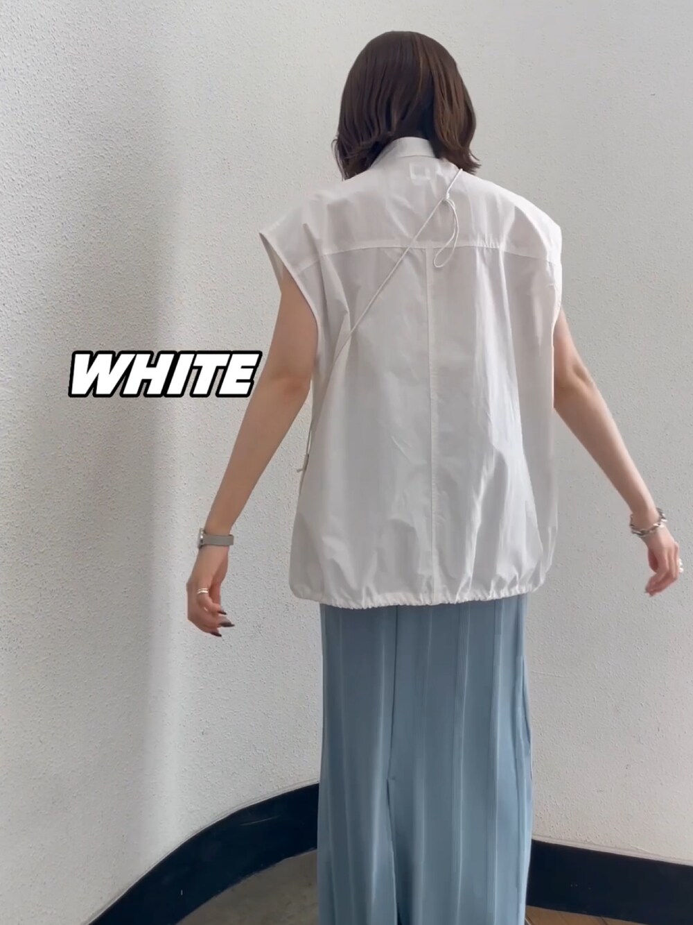 ホワイト系のショルダーバッグ、ホワイト系のキャミソール、ブルー系のスカートを着用したレディースの春コーディネートの4枚目の写真