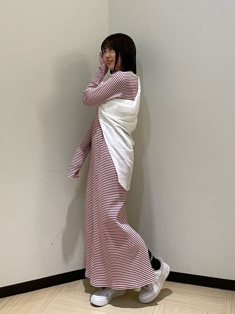 レッド系のワンピース、ホワイト系のシャツ/ブラウス、シルバー系のネックレスを着用したレディースの春コーディネートの3枚目の写真