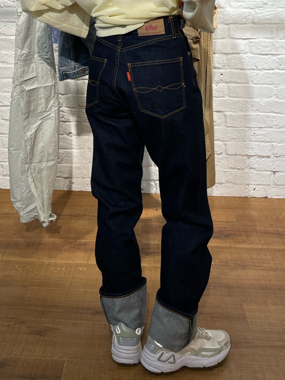 イエロー系のニット/セーター、ブルー系のデニムパンツを着用したレディースの春コーディネートの5枚目の写真