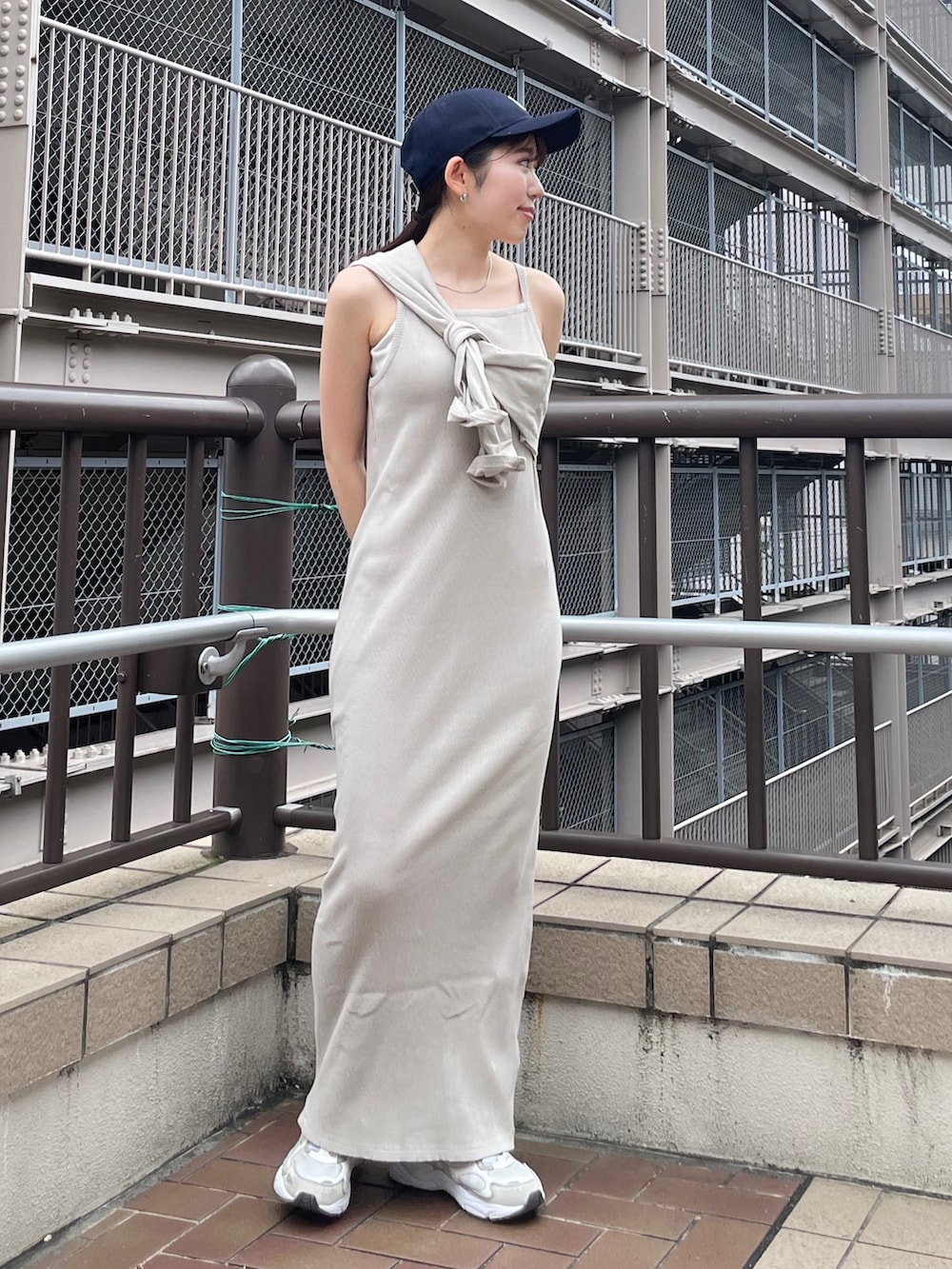 グレー系のワンピース、ブルー系のデニムジャケット、ブルー系のキャップを着用したレディースの夏コーディネートの3枚目の写真