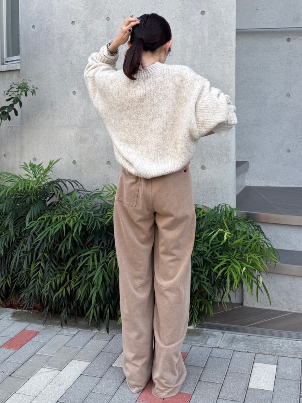 ベージュ系のスウェットパンツ、ブラック系のブーツ、ホワイト系のTシャツ/カットソーを着用したレディースの秋コーディネートの5枚目の写真