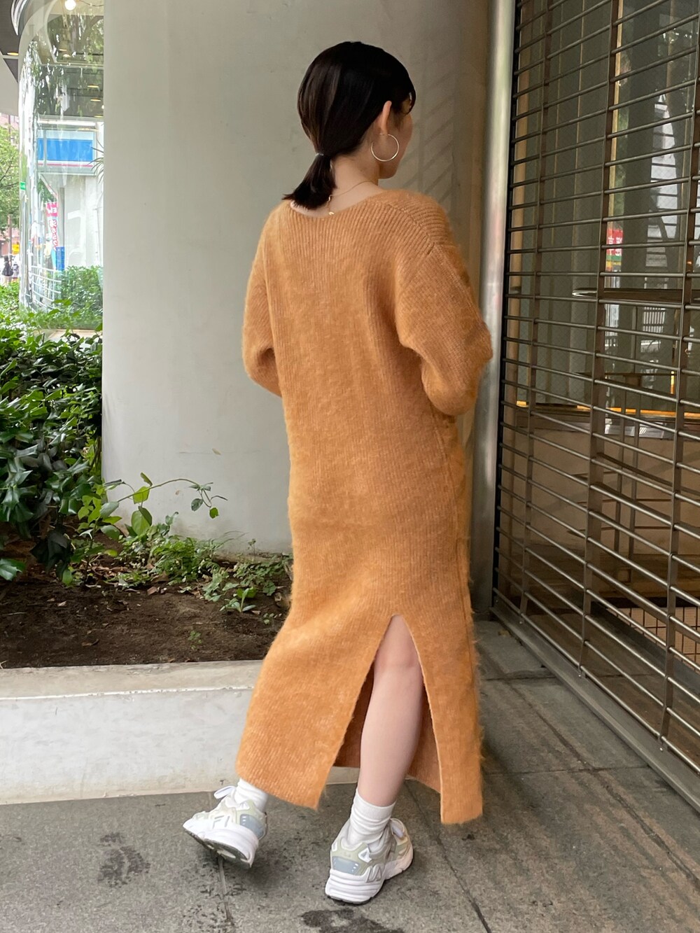 ホワイト系のハンドバッグ、オレンジ系のワンピースを着用したレディースの秋コーディネートの2枚目の写真