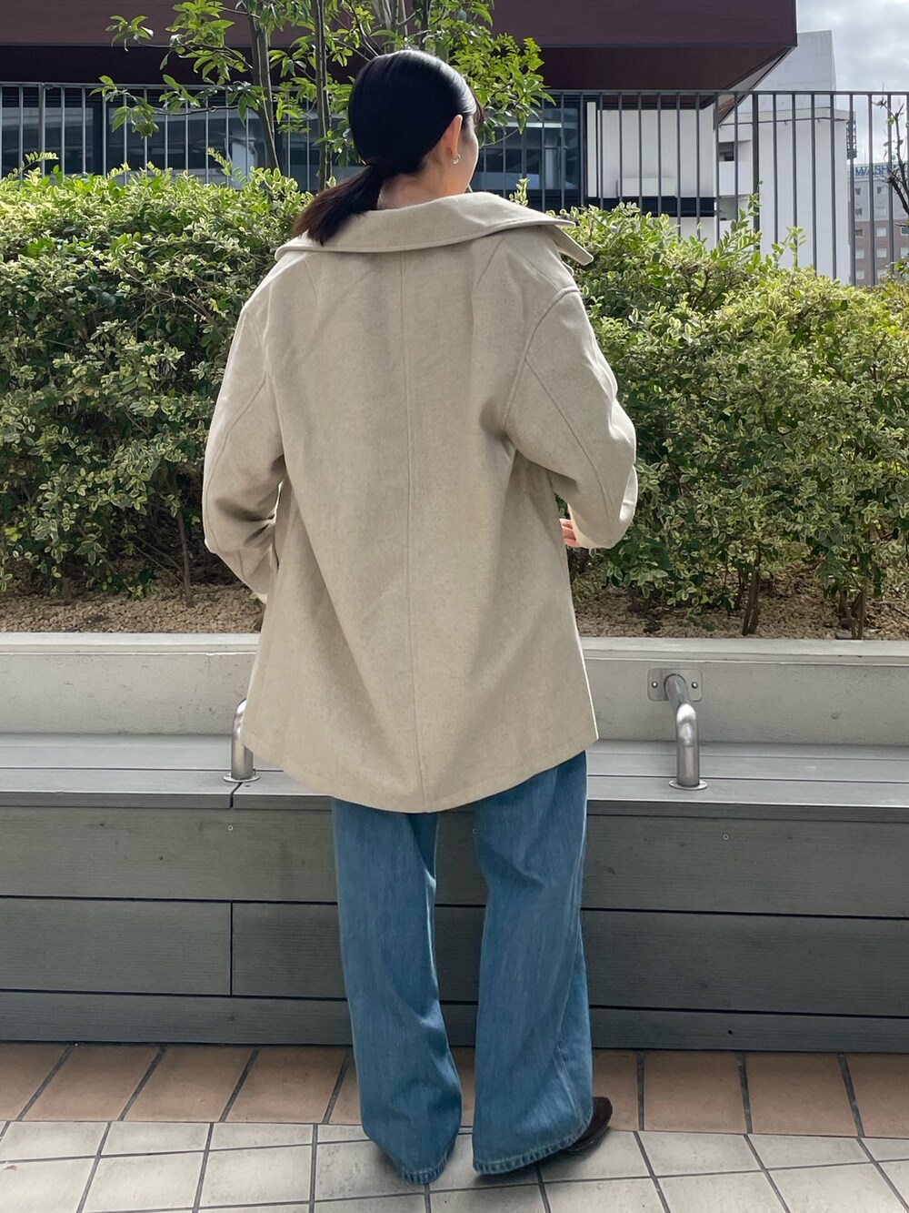 ブラック系のキャミソール、ブルー系のデニムパンツ、ブラック系のブーツを着用したレディースの秋コーディネートの5枚目の写真