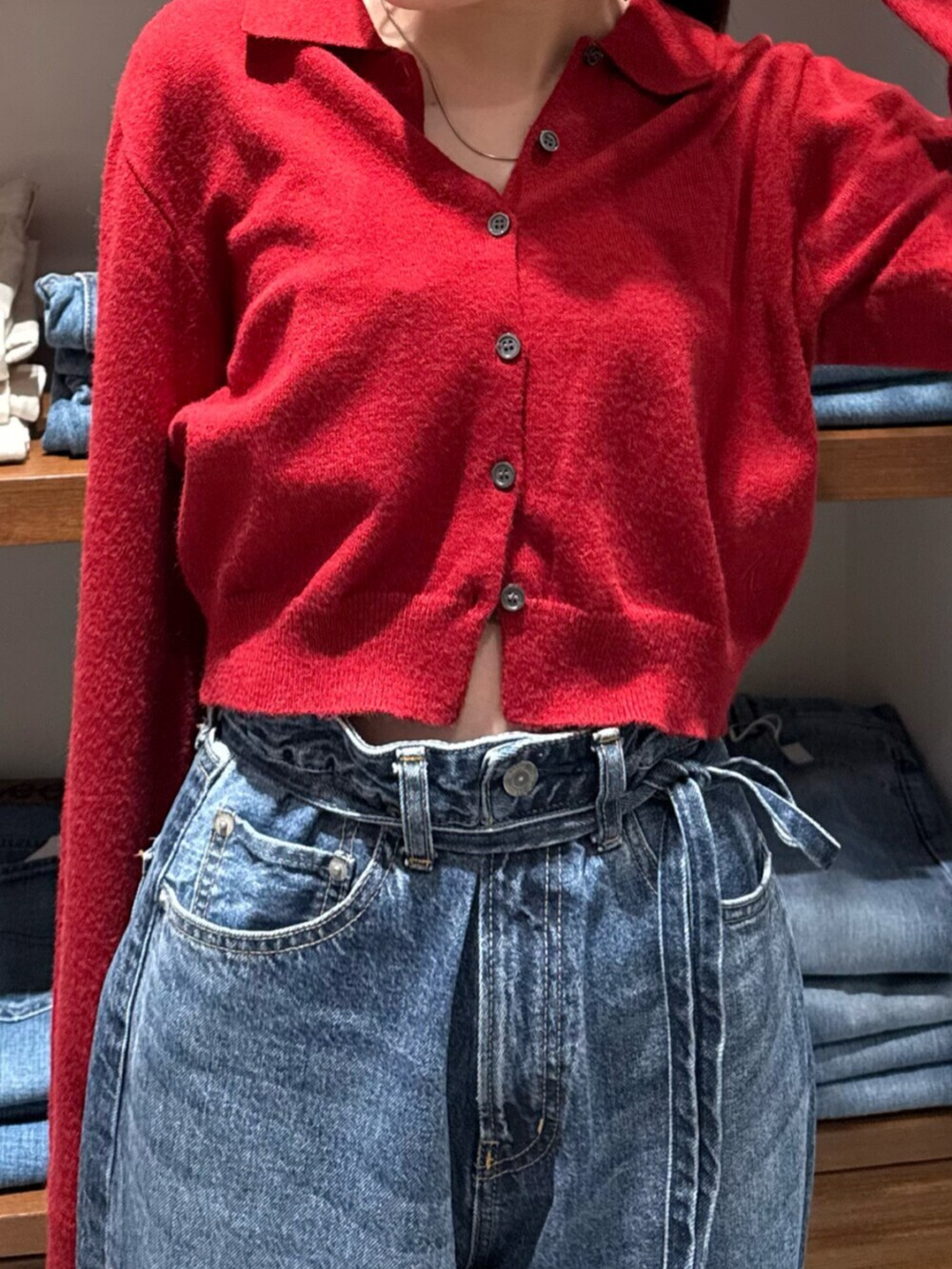 レッド系のカーディガン/ボレロ、ブルー系のデニムパンツを着用したレディースの秋コーディネートの7枚目の写真