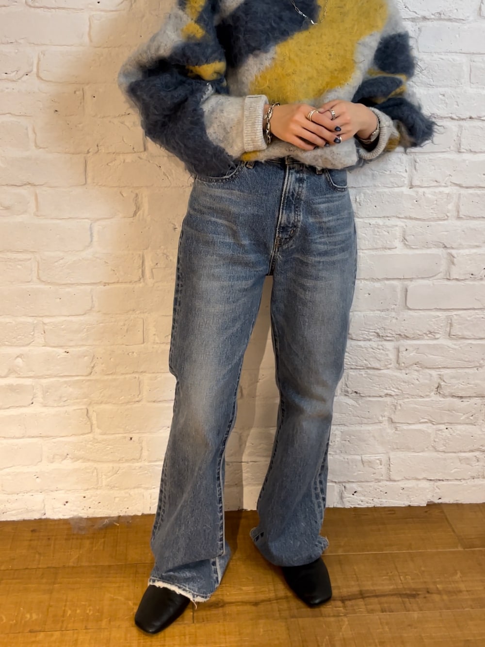 ブルー系のデニムパンツ、ブラック系のブーツ、ブルー系のニット/セーターを着用したレディースの夏コーディネートの7枚目の写真