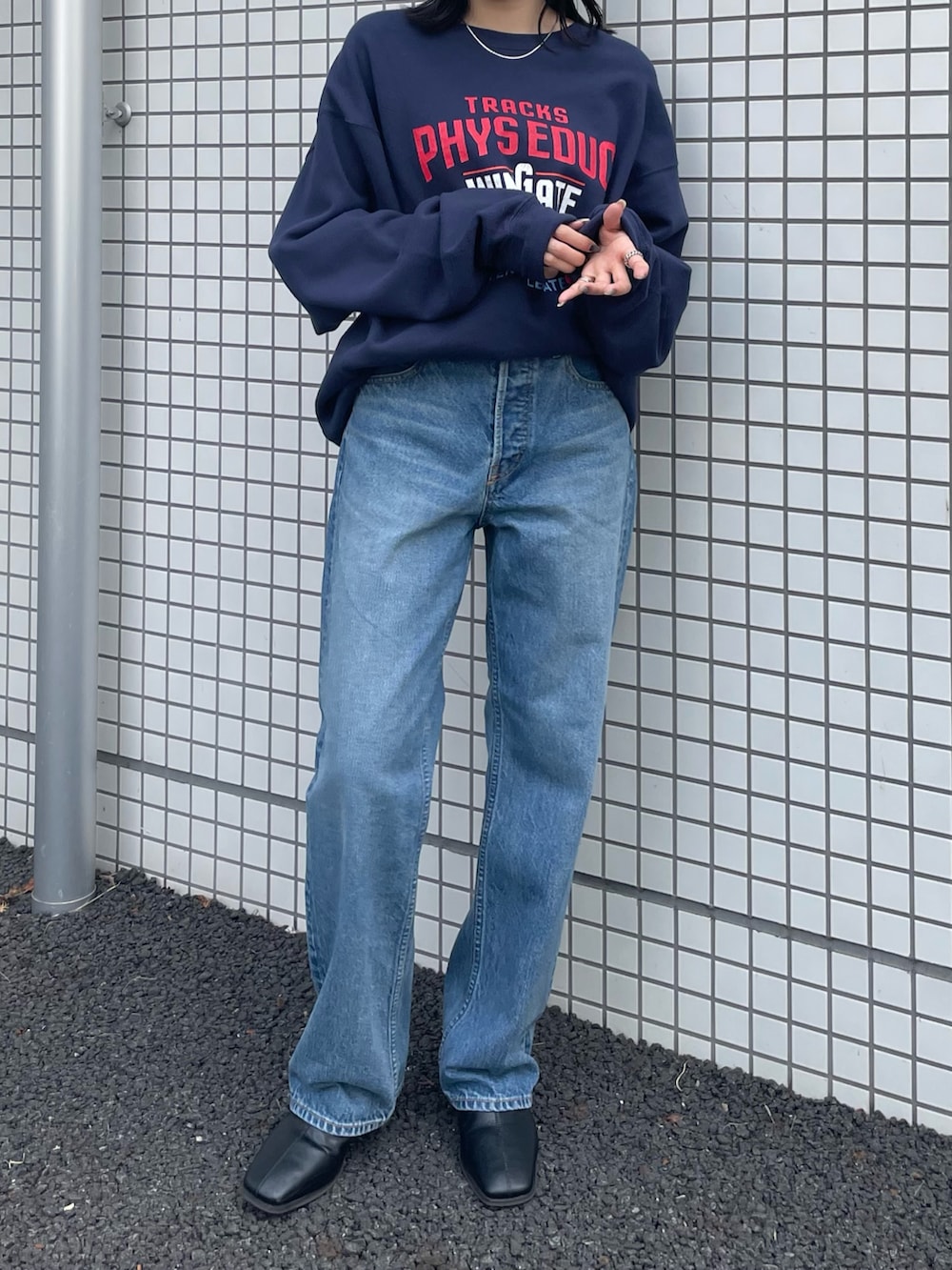 ブラック系のブーツ、ブルー系のスウェット、ブルー系のデニムパンツを着用したレディースの冬コーディネートの2枚目の写真