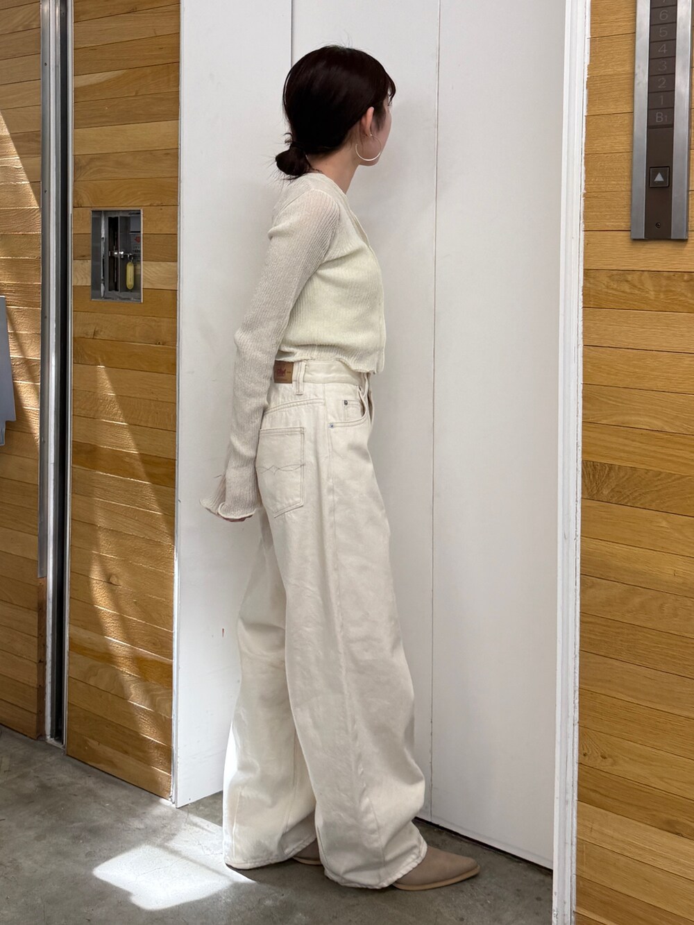 ホワイト系のデニムパンツ、ベージュ系のブーツ、ホワイト系のカーディガン/ボレロを着用したレディースの春コーディネートの6枚目の写真