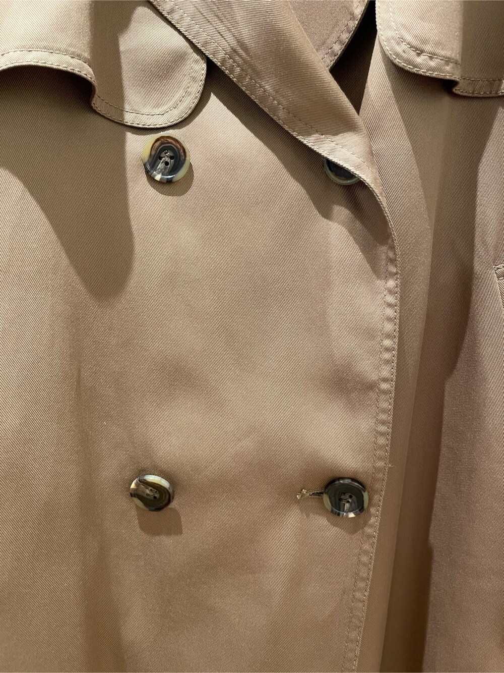 ブラウン系のトレンチコート、ブラック系のブーツ、ホワイト系のワンピースを着用したレディースの秋コーディネートの8枚目の写真