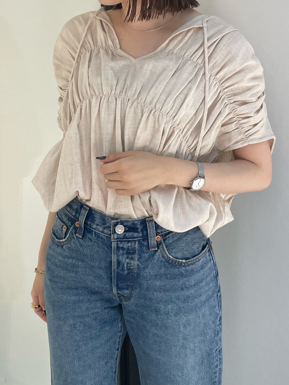 ホワイト系のシャツ/ブラウス、ブラック系のスニーカー、ブルー系のデニムパンツを着用したレディースの夏コーディネートの6枚目の写真