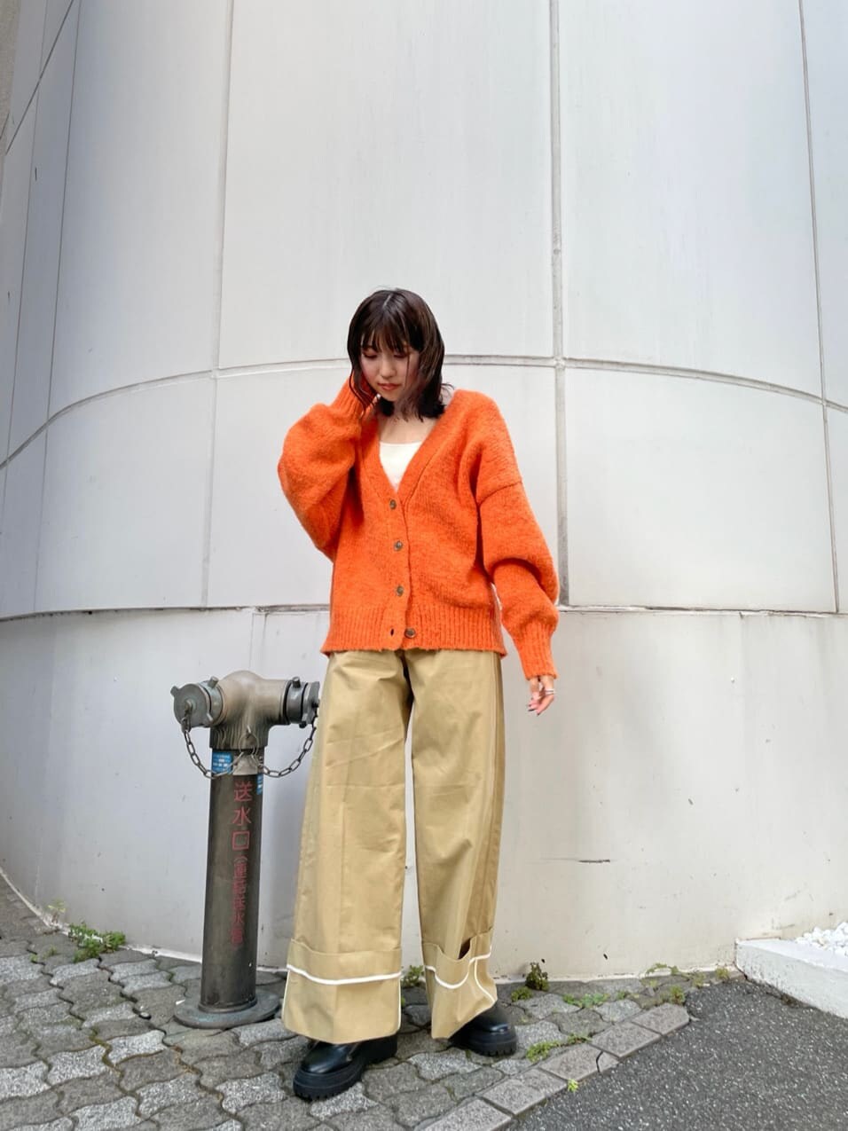 ベージュ系のチノパンツ、オレンジ系のカーディガン/ボレロを着用したレディースの夏コーディネートの5枚目の写真