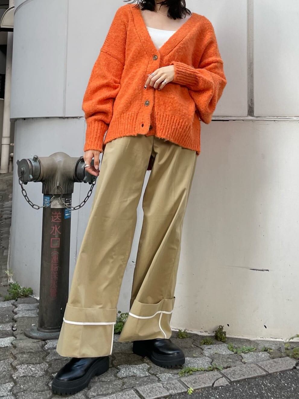 ベージュ系のチノパンツ、オレンジ系のカーディガン/ボレロを着用したレディースの夏コーディネートの2枚目の写真