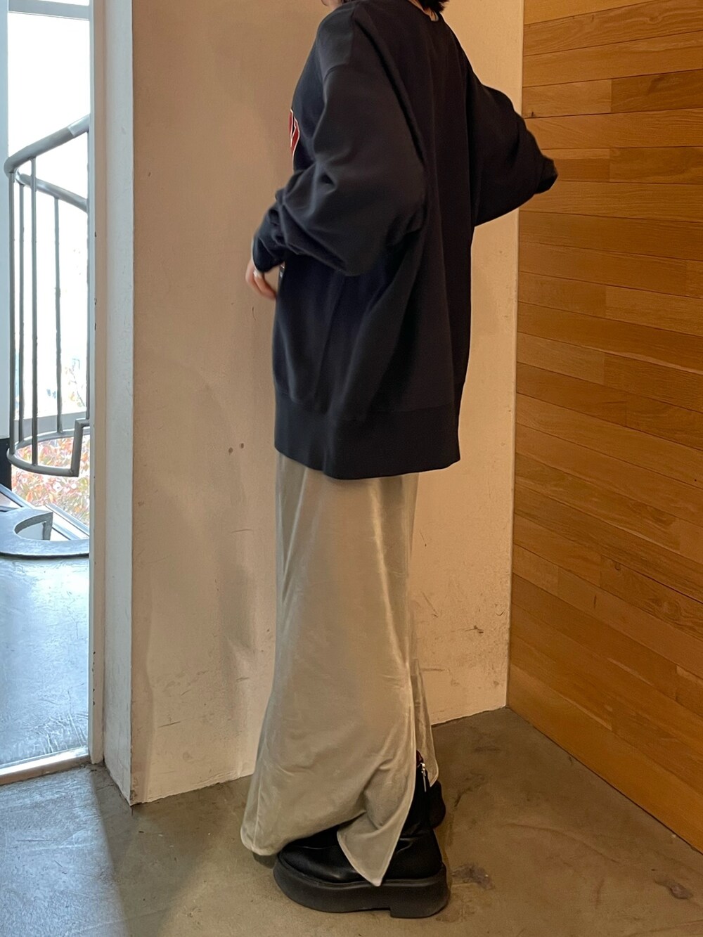 グレー系のスカート、ブラック系のブーツ、ブルー系のTシャツ/カットソーを着用したレディースの秋コーディネートの5枚目の写真