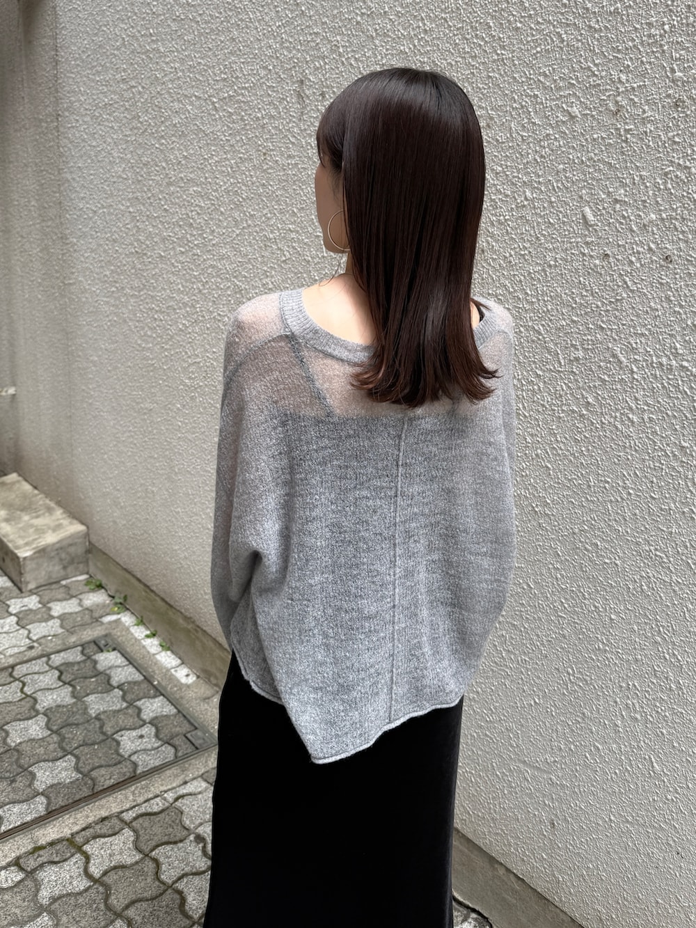 ブラック系のスカート、ブラウン系のブーツ、グレー系のニット/セーターを着用したレディースの秋コーディネートの4枚目の写真