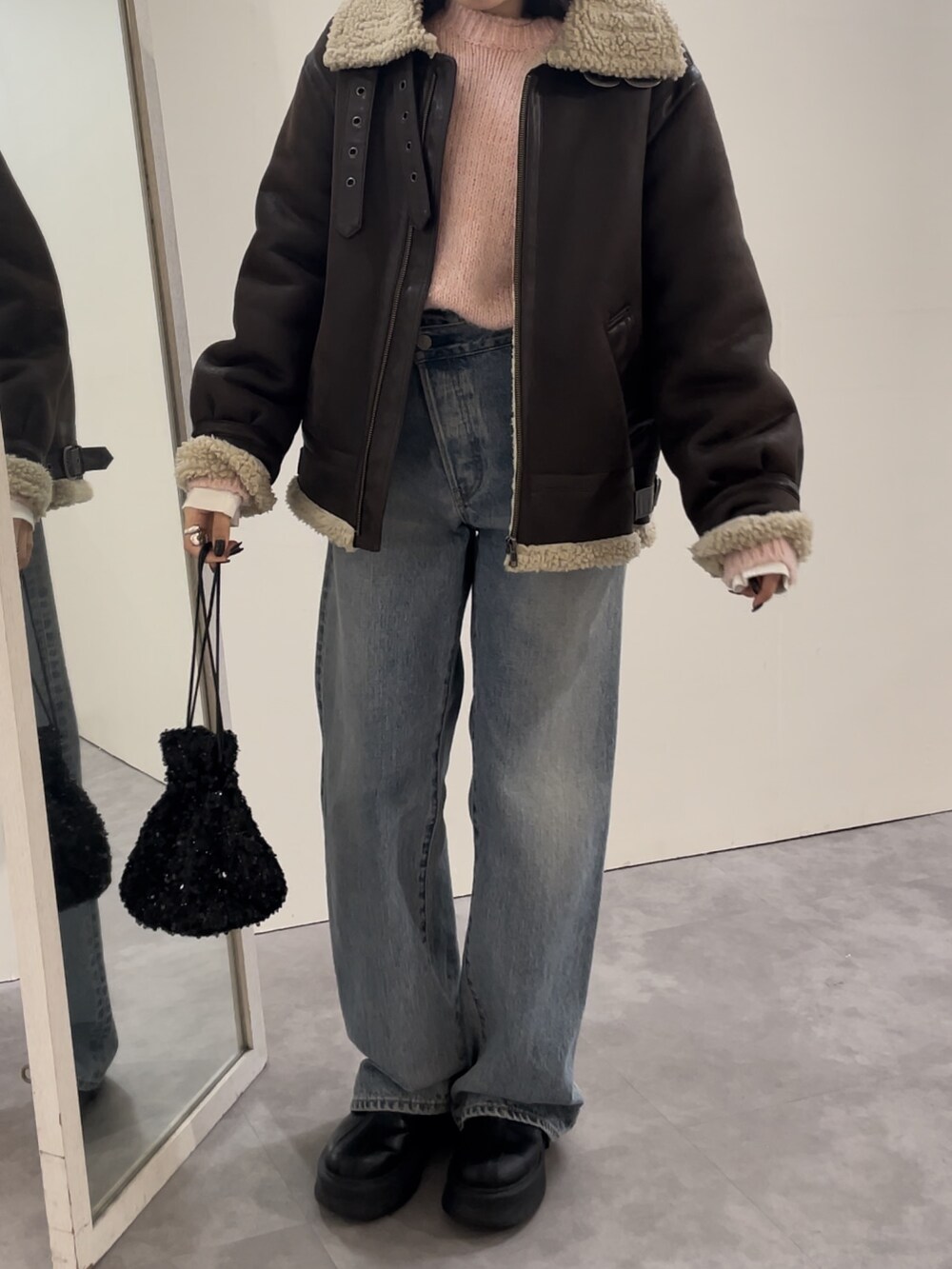 ブルー系のデニムパンツ、ブラック系のブーツ、ピンク系のニット/セーターを着用したレディースの冬コーディネートの2枚目の写真