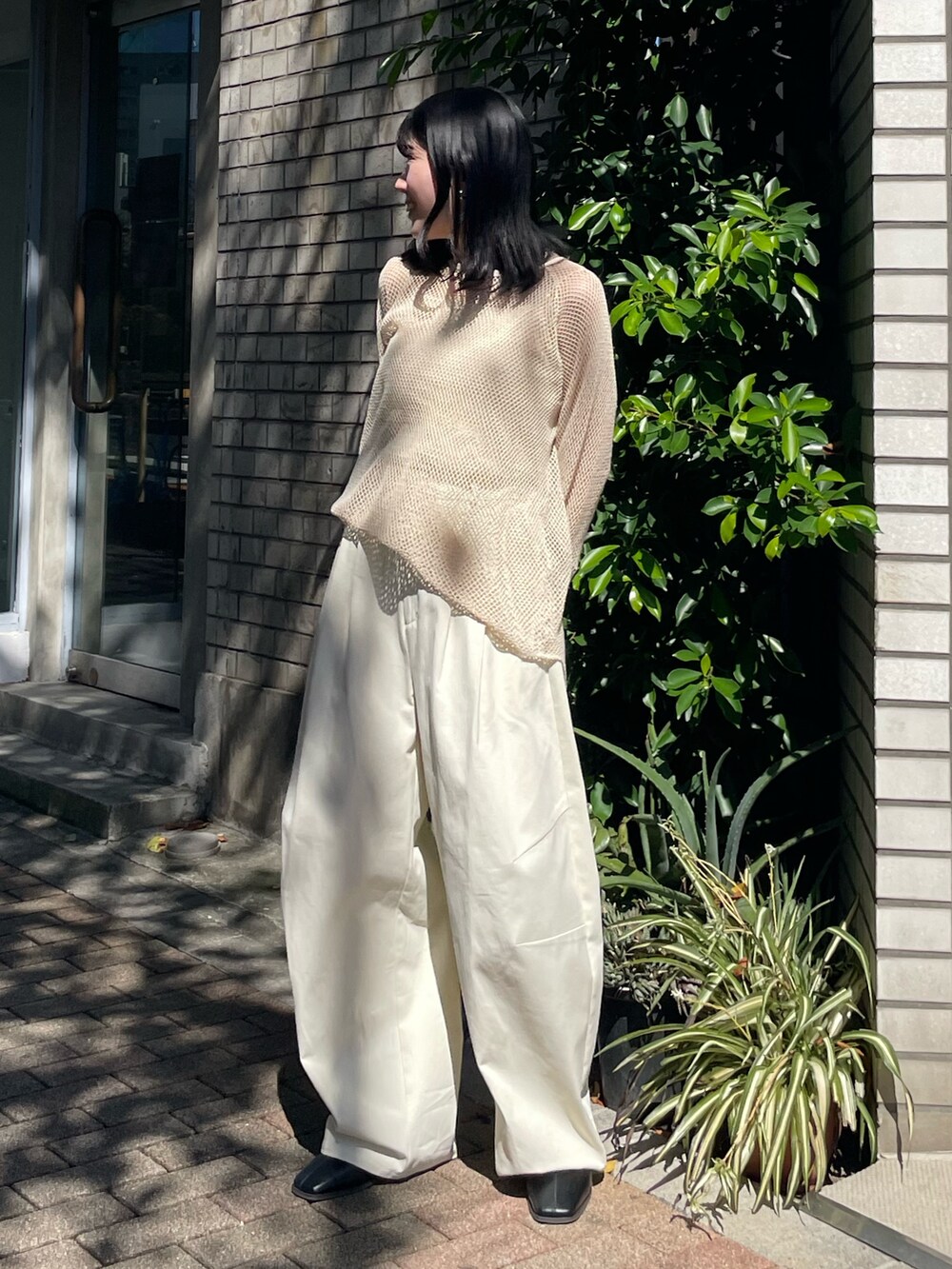 ブラック系のブーツ、ホワイト系のチノパンツ、ホワイト系のTシャツ/カットソーを着用したレディースの冬コーディネートの3枚目の写真