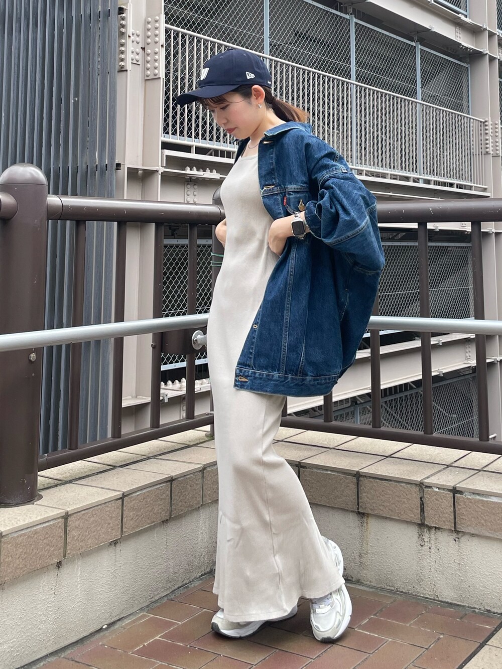 グレー系のワンピース、ブルー系のデニムジャケット、ブルー系のキャップを着用したレディースの夏コーディネートの7枚目の写真