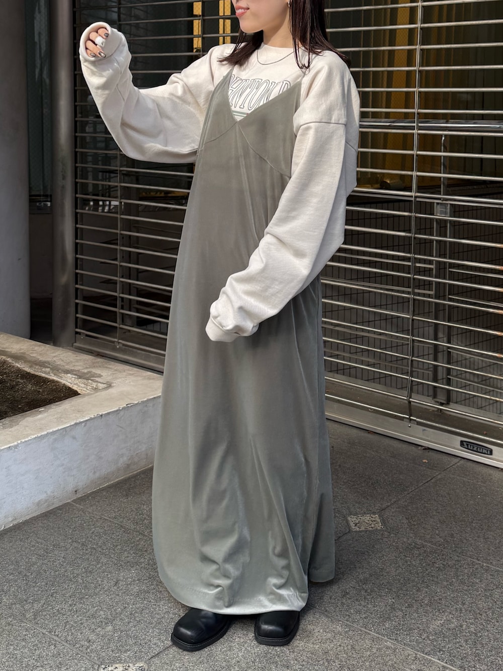 グレー系のワンピース、ホワイト系のスウェット、ブラック系のブーツを着用したレディースの冬コーディネートの5枚目の写真