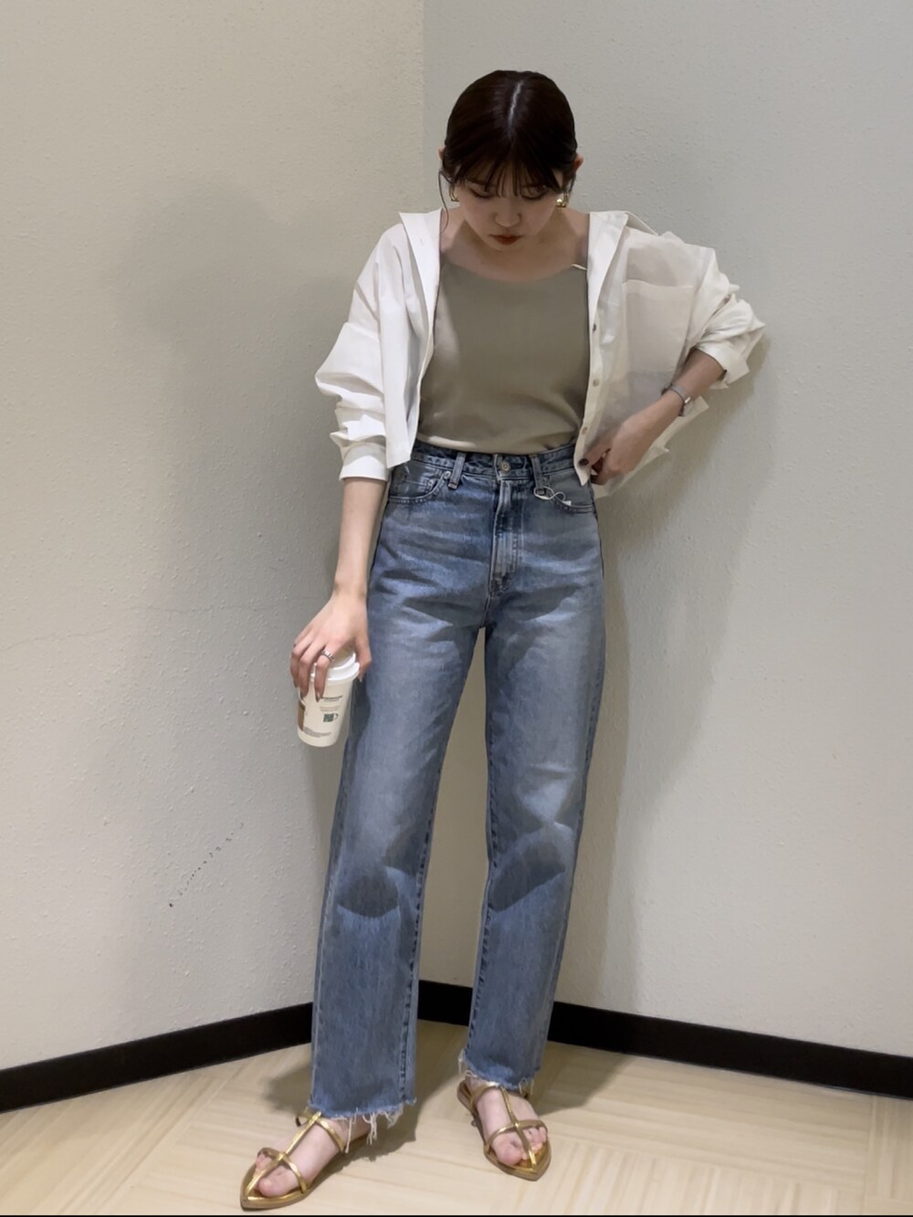 ブルー系のデニムパンツ、ベージュ系のキャミソール、ホワイト系のシャツ/ブラウスを着用したレディースの春コーディネートの3枚目の写真