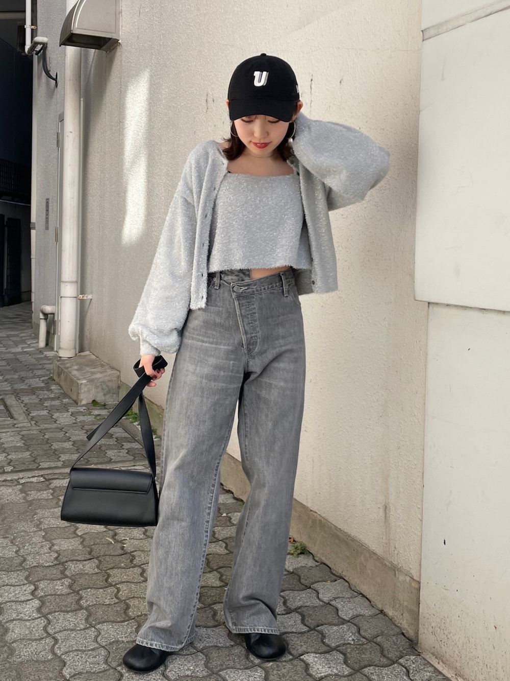 ブラック系のショルダーバッグ、ブラック系のブーツ、ブラック系のデニムパンツを着用したレディースの冬コーディネートの3枚目の写真