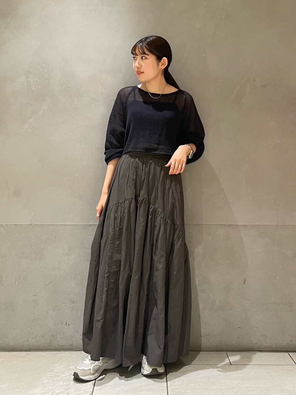 グレー系のスカート、グレー系のTシャツ/カットソーを着用したレディースの夏コーディネートの2枚目の写真