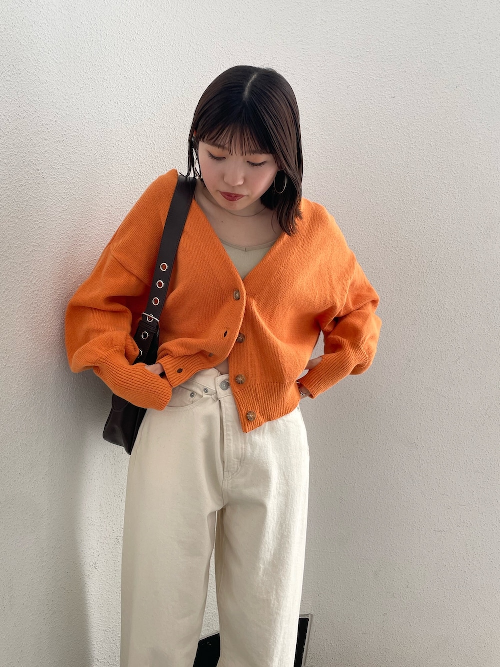 グレー系のキャミソール、ホワイト系のデニムパンツ、ホワイト系のサンダルを着用したレディースの春コーディネートの3枚目の写真