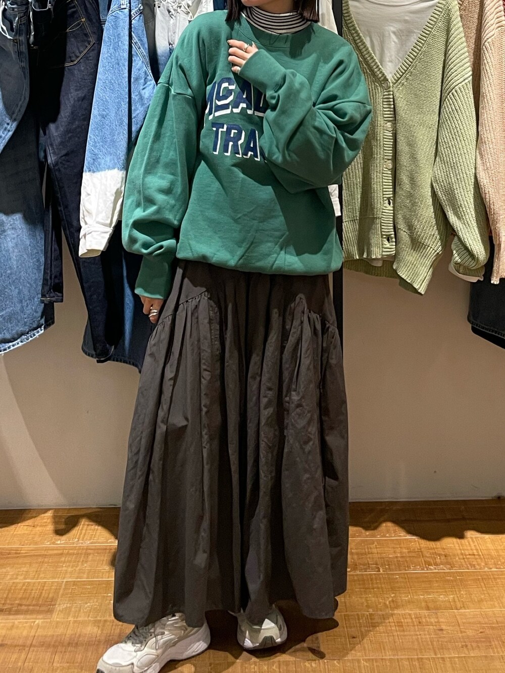 グレー系のスカート、グリーン系のスウェット、ホワイト系のニット/セーターを着用したレディースの冬コーディネートの7枚目の写真