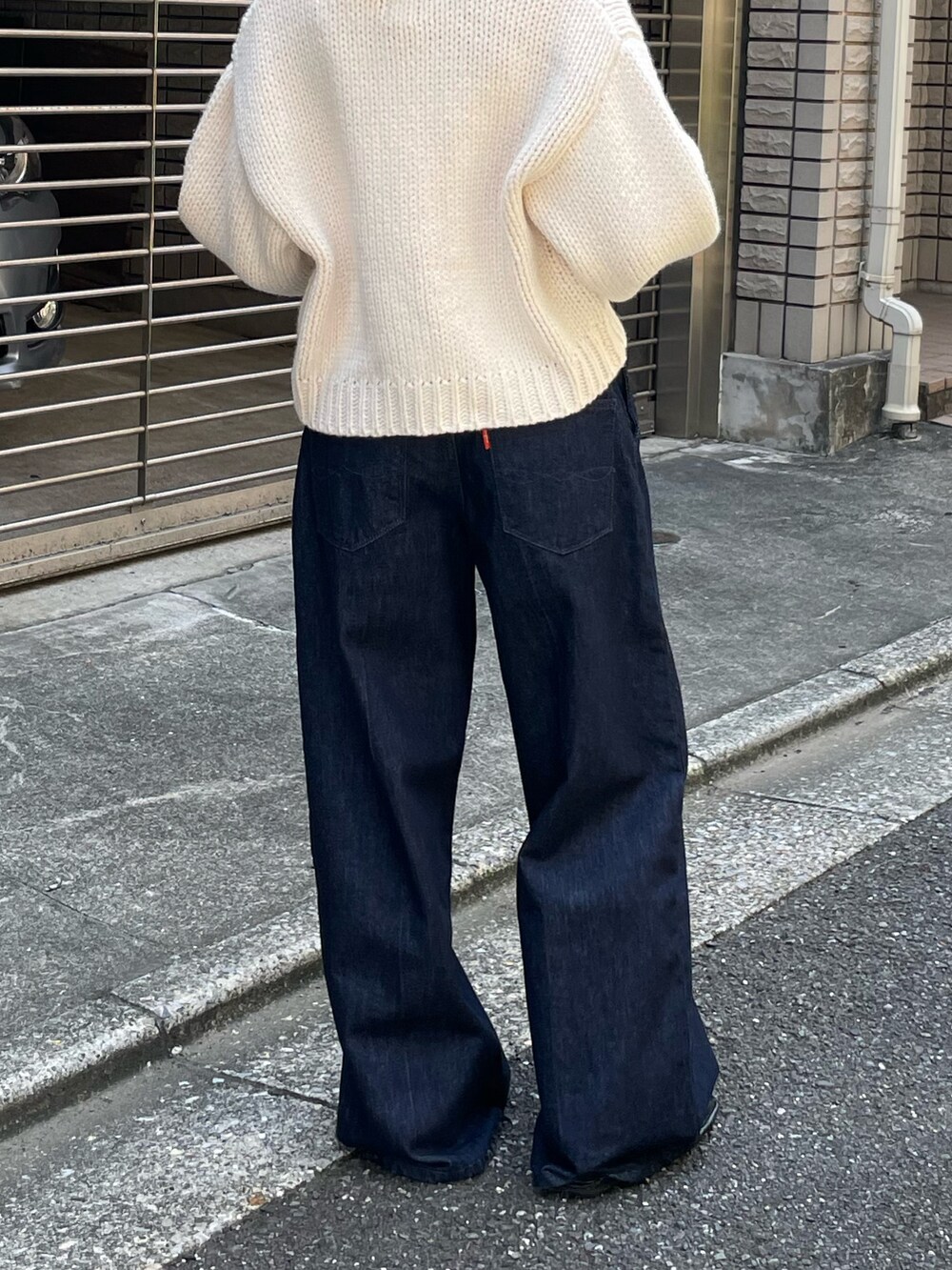 ブラック系のローファー、ブルー系のデニムパンツ、ホワイト系のカーディガン/ボレロを着用したレディースの秋コーディネートの7枚目の写真