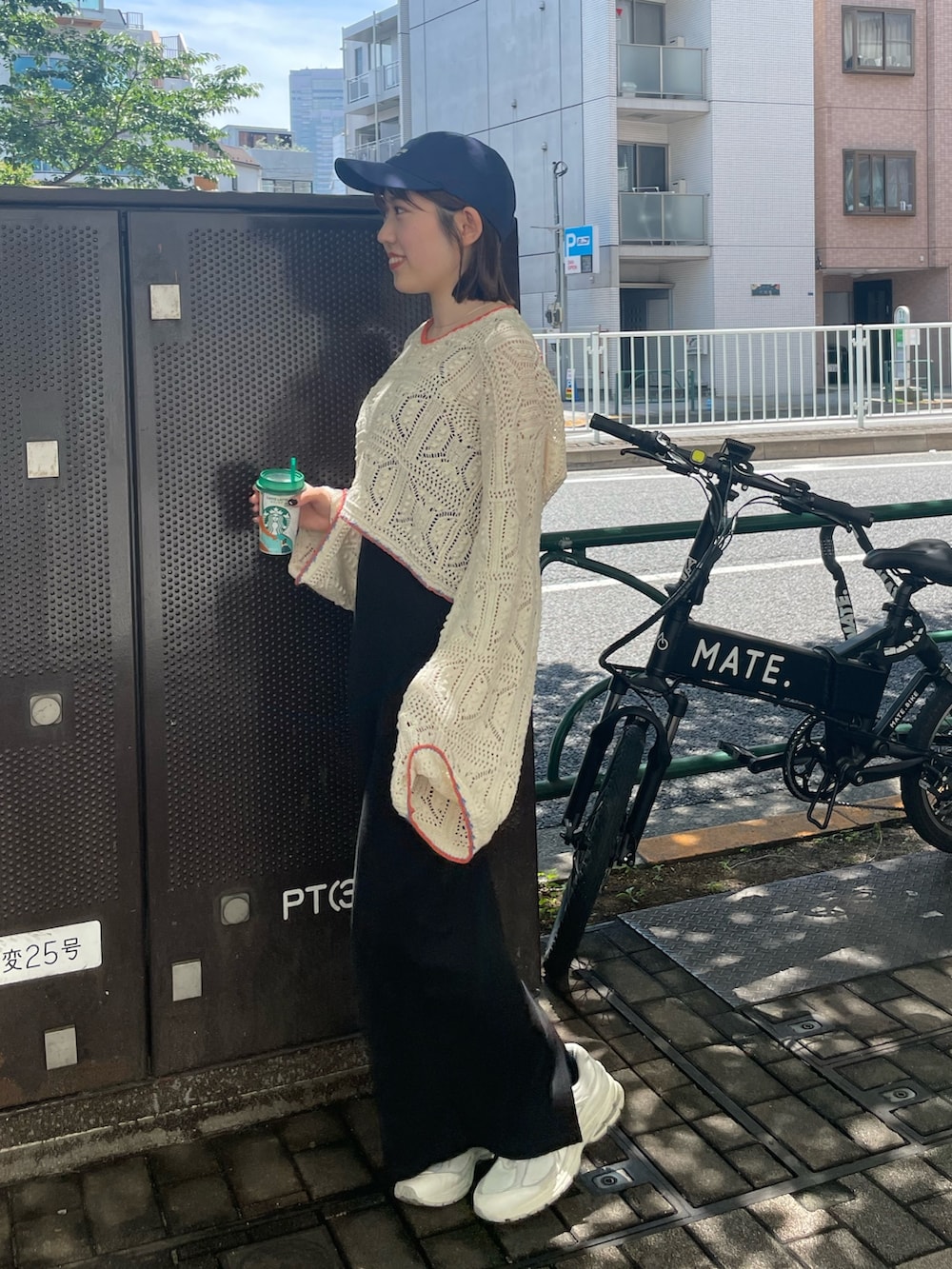 ブラック系のワンピース、ホワイト系のニット/セーター、ブルー系のキャップを着用したレディースの夏コーディネートの7枚目の写真