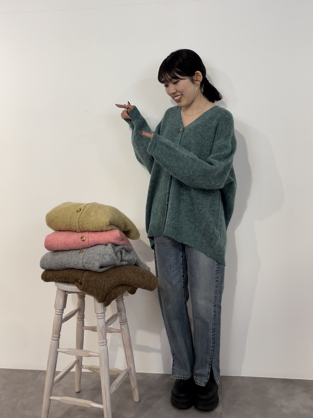 ブルー系のデニムパンツ、ブラック系のブーツ、グリーン系のカーディガン/ボレロを着用したレディースの冬コーディネートの5枚目の写真