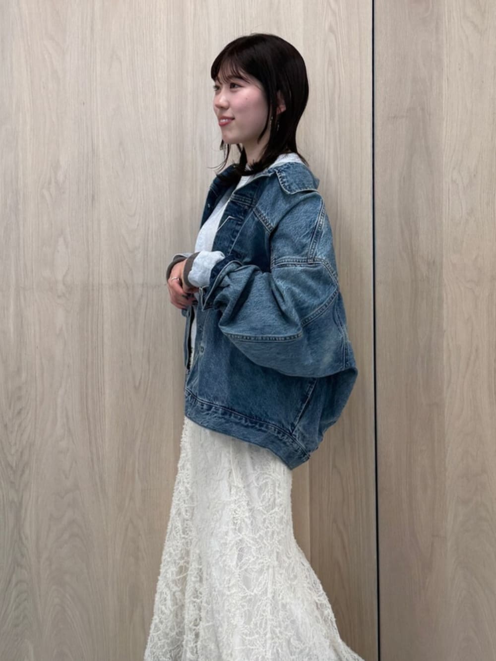 ホワイト系のスカート、ブルー系のデニムジャケット、グレー系のニット/セーターを着用したレディースの冬コーディネートの4枚目の写真