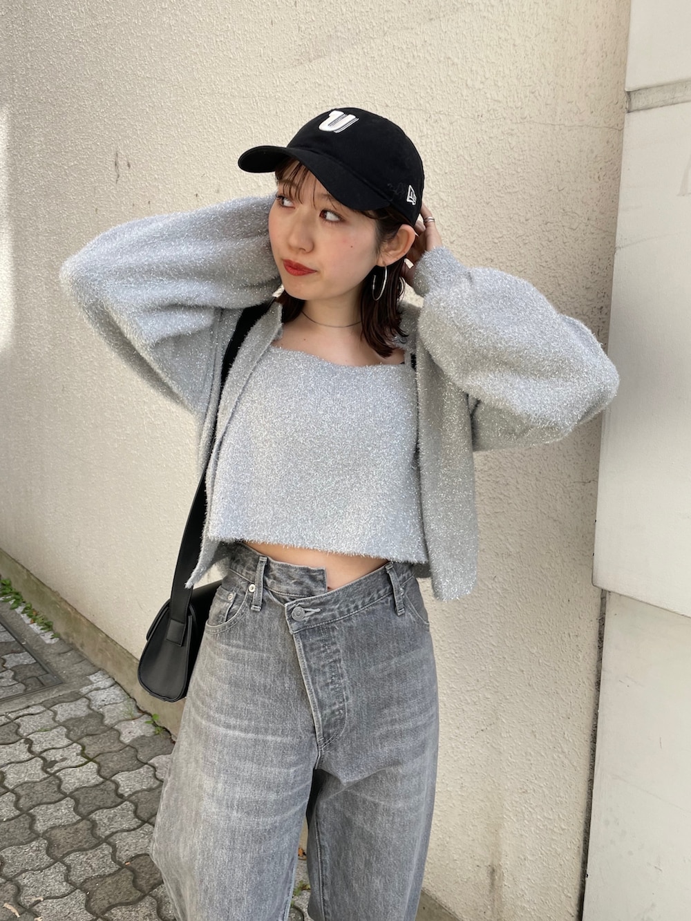 ブラック系のショルダーバッグ、ブラック系のブーツ、ブラック系のデニムパンツを着用したレディースの冬コーディネートの2枚目の写真