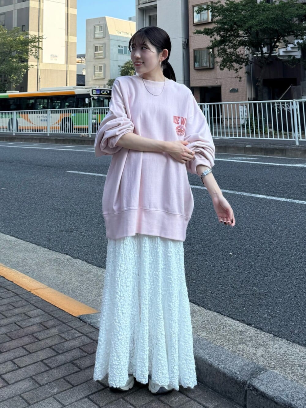 ホワイト系のスカート、ピンク系のスウェットを着用したレディースの秋コーディネートの2枚目の写真