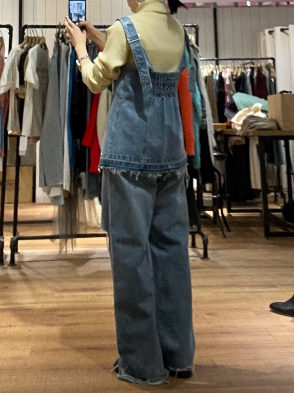 ブラック系のブーツ、ブルー系のタンクトップ、イエロー系のニット/セーターを着用したレディースの秋コーディネートの4枚目の写真