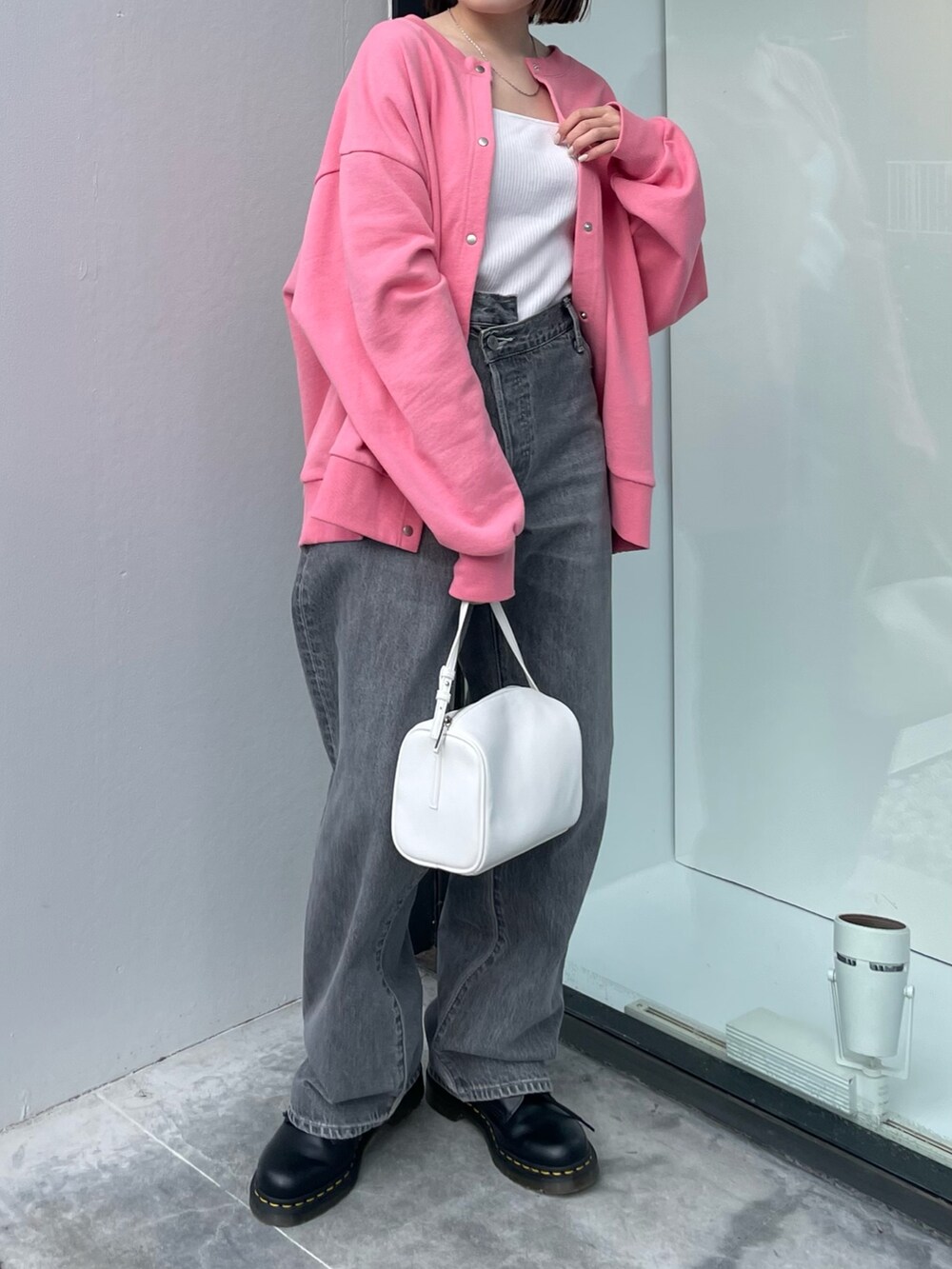ピンク系のカーディガン/ボレロ、ホワイト系のハンドバッグ、ブラック系のデニムパンツを着用したレディースの冬コーディネートの3枚目の写真
