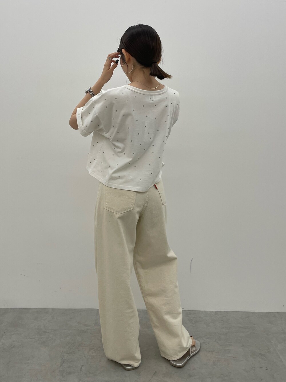 ホワイト系のデニムパンツ、シルバー系のサンダル、ホワイト系のTシャツ/カットソーを着用したレディースの春コーディネートの5枚目の写真