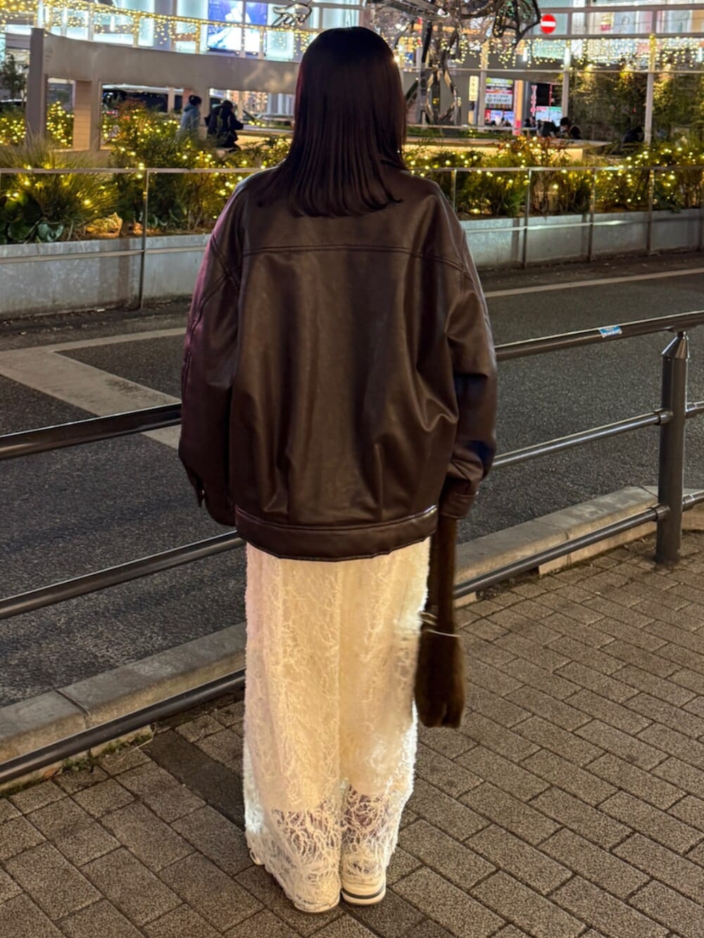 ブラウン系のハンドバッグ、ホワイト系のワンピース、ブラウン系のブルゾンを着用したレディースの冬コーディネートの4枚目の写真