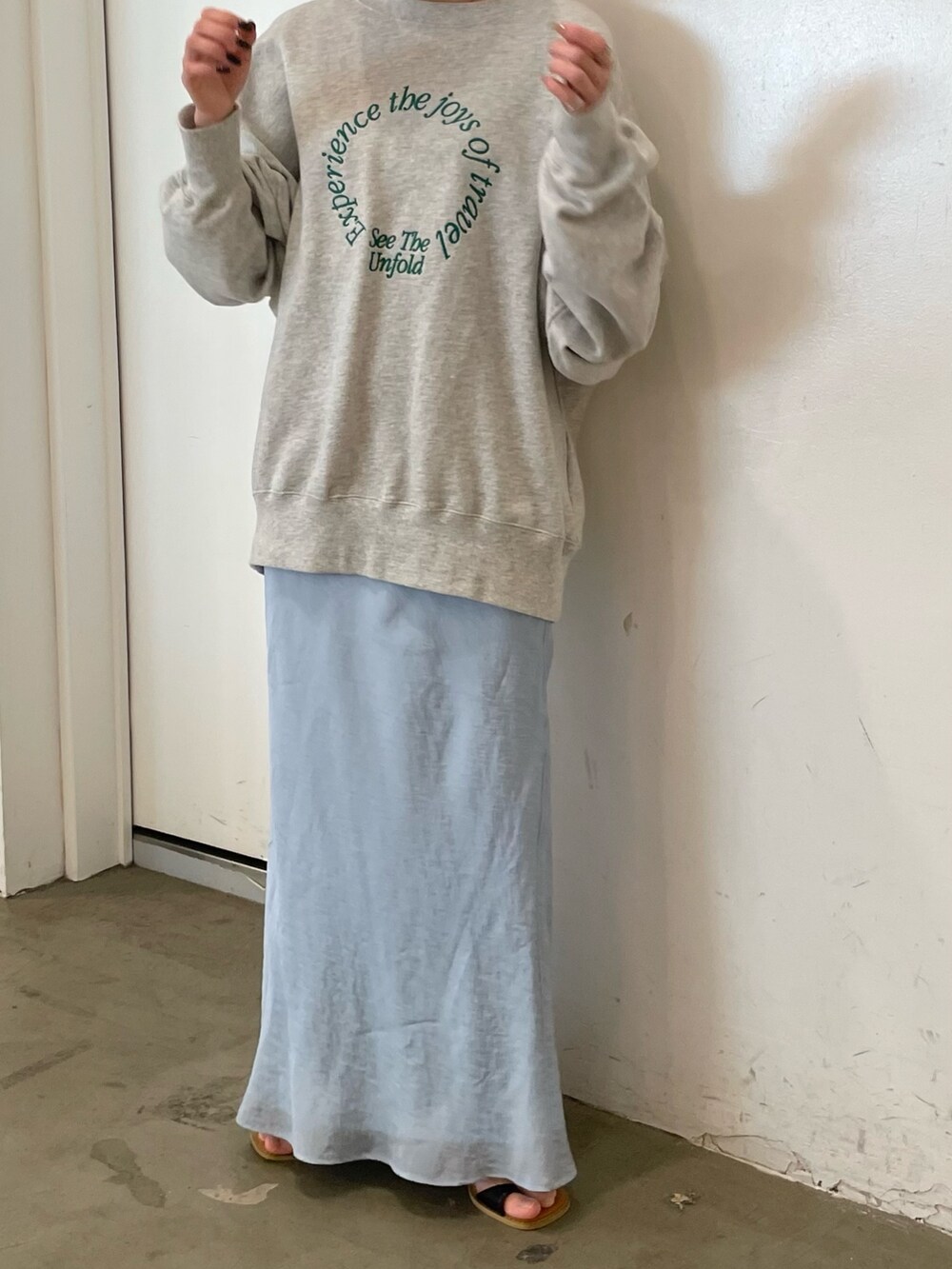 グレー系のスウェット、ブルー系のスカート、ブラック系のサンダルを着用したレディースの冬コーディネートの5枚目の写真