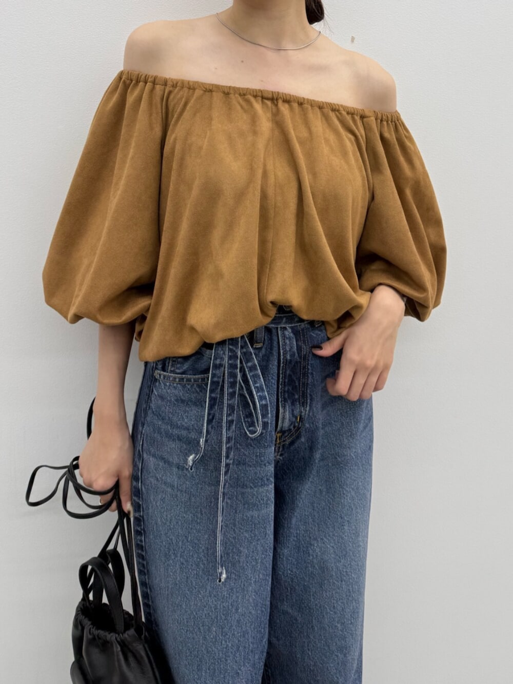 ブラウン系のブーツ、ブラック系のショルダーバッグ、ブルー系のデニムパンツを着用したレディースの秋コーディネートの7枚目の写真