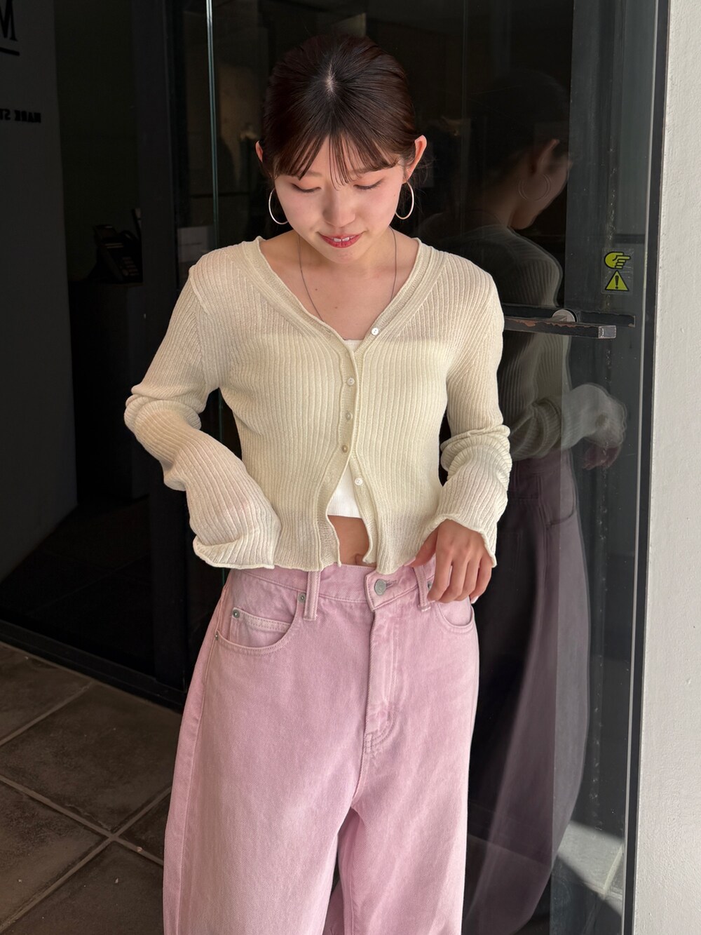 ピンク系のデニムパンツ、ブラック系のサンダル、ホワイト系のカーディガン/ボレロを着用したレディースの春コーディネートの4枚目の写真