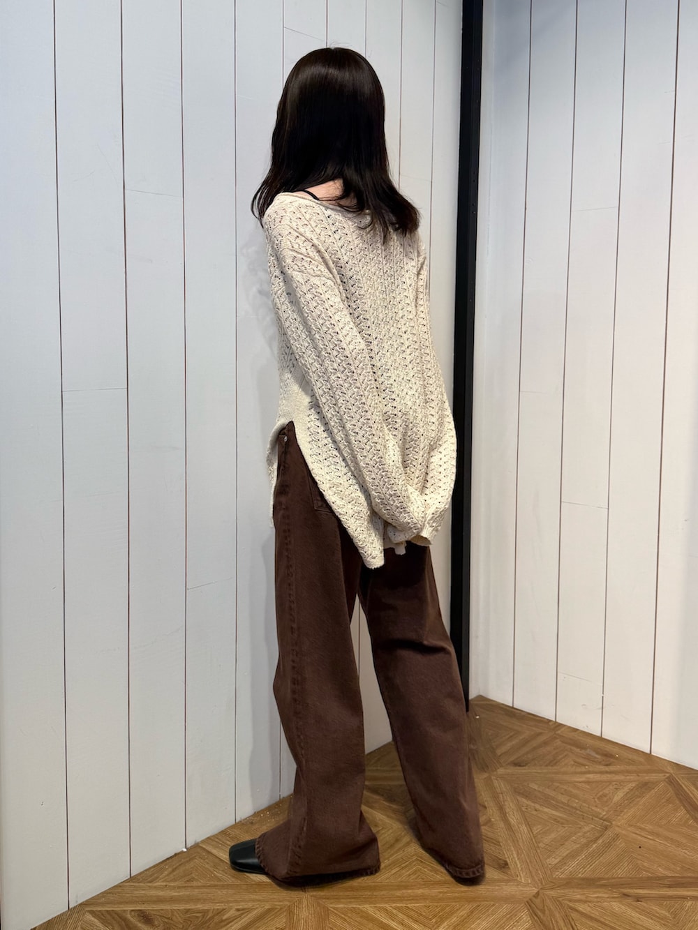 ブラウン系のデニムパンツ、ブラック系のサンダル、ベージュ系のニット/セーターを着用したレディースの春コーディネートの5枚目の写真