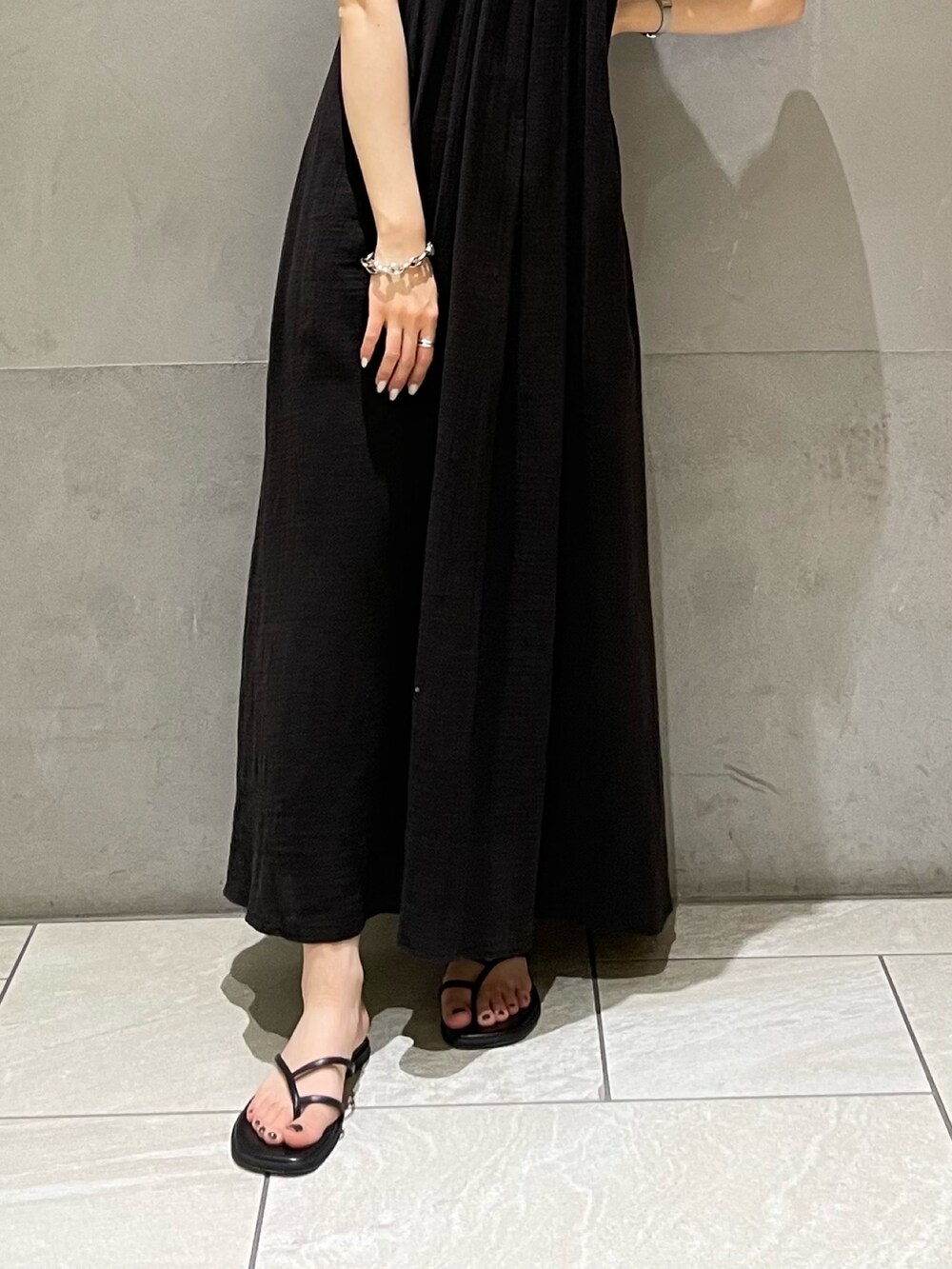 ブルー系のタンクトップ、ブラック系のワンピース、ブラック系のサンダルを着用したレディースの夏コーディネートの6枚目の写真