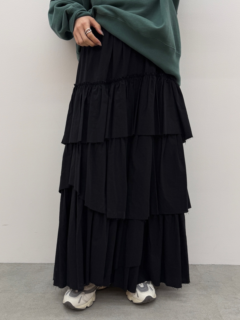 ブラック系のスカート、グリーン系のスウェットを着用したレディースの冬コーディネートの4枚目の写真