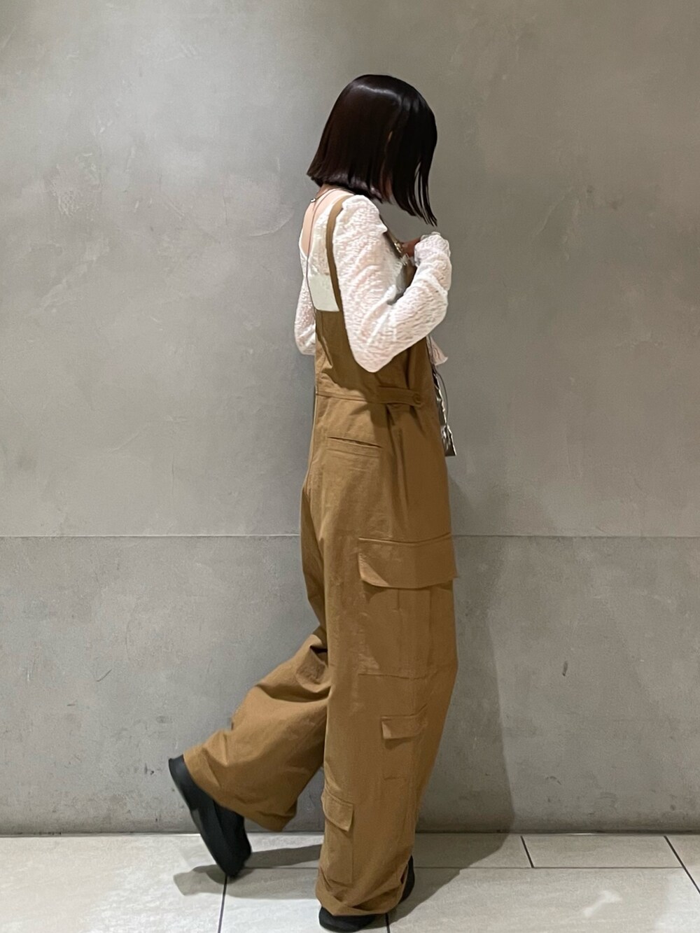 ホワイト系のTシャツ/カットソー、ブラック系のブーツ、シルバー系のショルダーバッグを着用したレディースの冬コーディネートの7枚目の写真