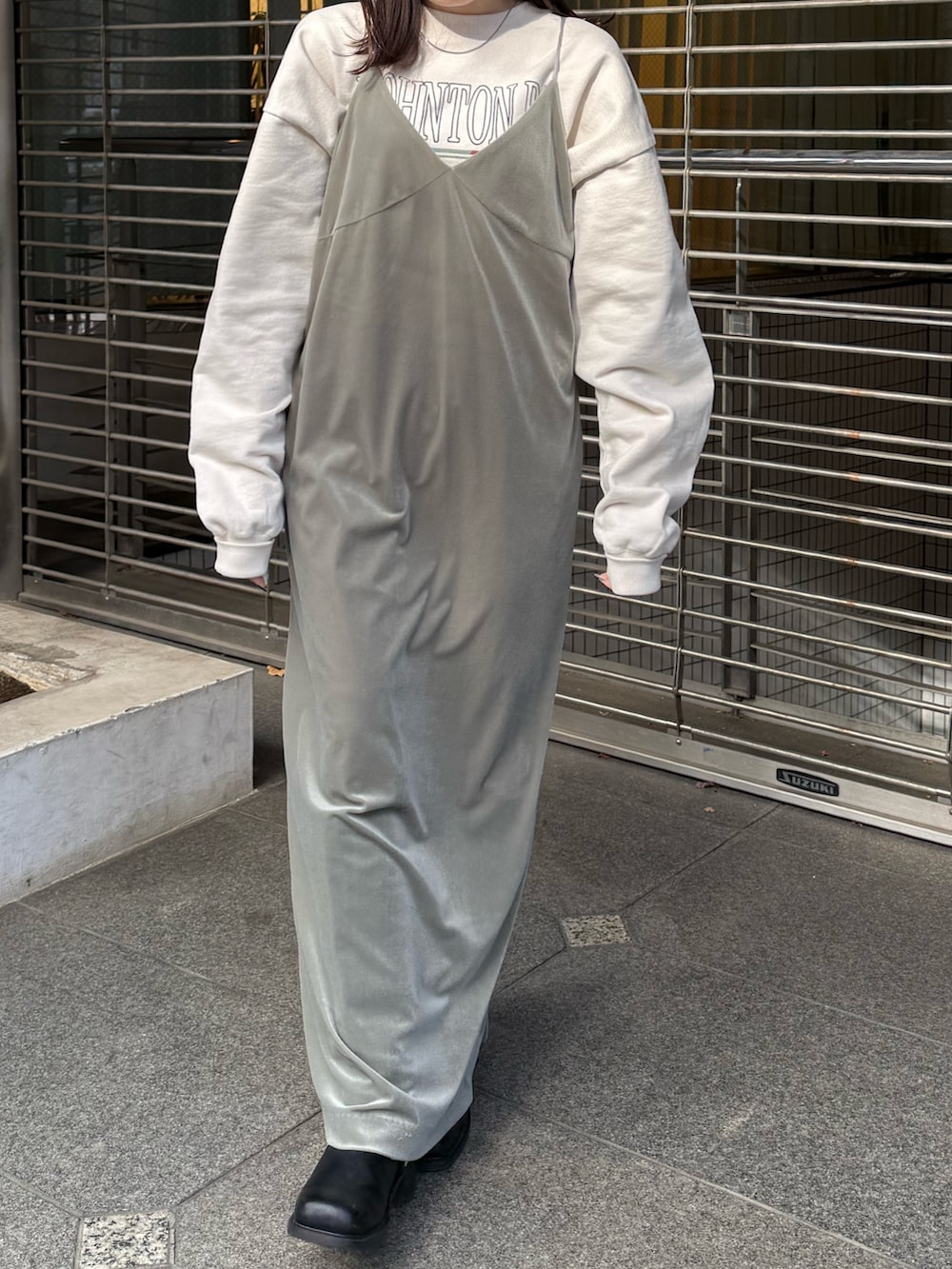 グレー系のワンピース、ホワイト系のスウェット、ブラック系のブーツを着用したレディースの冬コーディネートの7枚目の写真