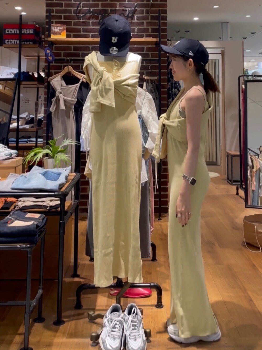 イエロー系のワンピース、ブルー系のキャップを着用したレディースの夏コーディネートの4枚目の写真